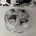 The Ace Luffy Ashtray by SpicedAnime is a round glass ashtray featuring black-and-white manga art of two intense, muscular, shirtless characters with manga panels in the background—an eye-catching addition for anime fans.
